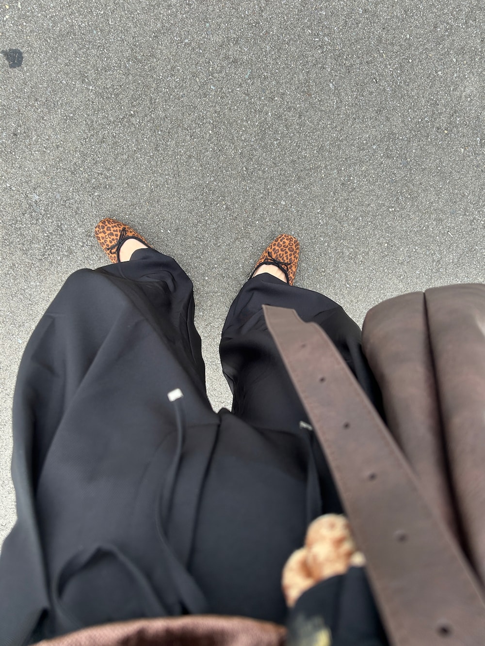 ブラック系のスラックス、ブラウン系のTシャツ/カットソー、ゴールド系のブレスレットを着用したレディースの秋コーディネートの3枚目の写真