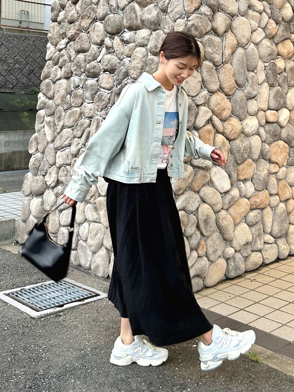 ブルー系のデニムジャケット、ホワイト系のTシャツ/カットソー、ブラック系のスカートを着用したレディースの秋コーディネートの3枚目の写真