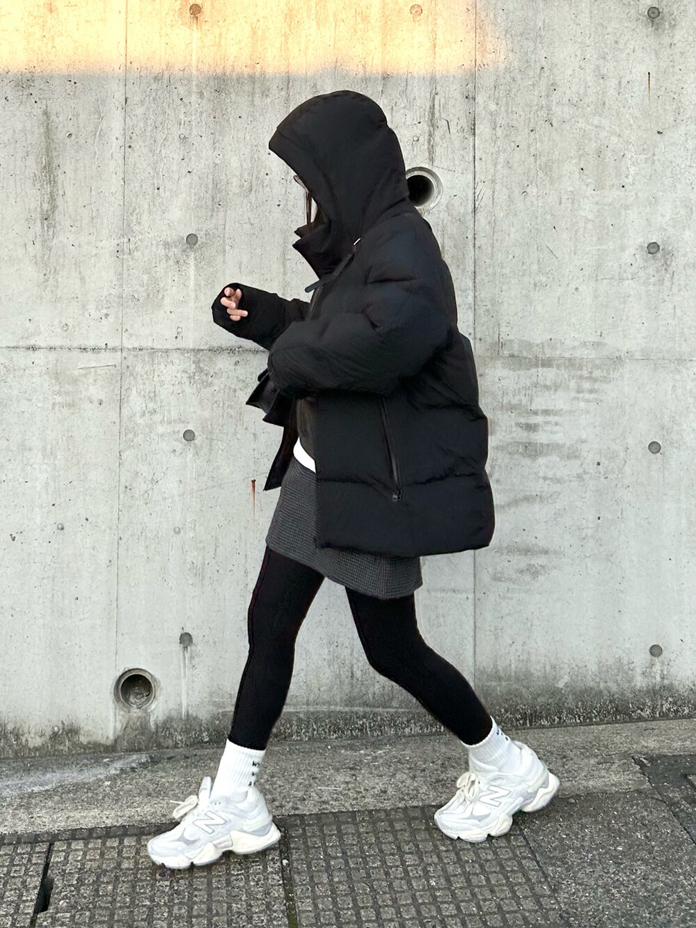 グレー系のスウェット、ホワイト系のTシャツ/カットソー、ブラック系のスカートを着用したレディースの冬コーディネートの2枚目の写真