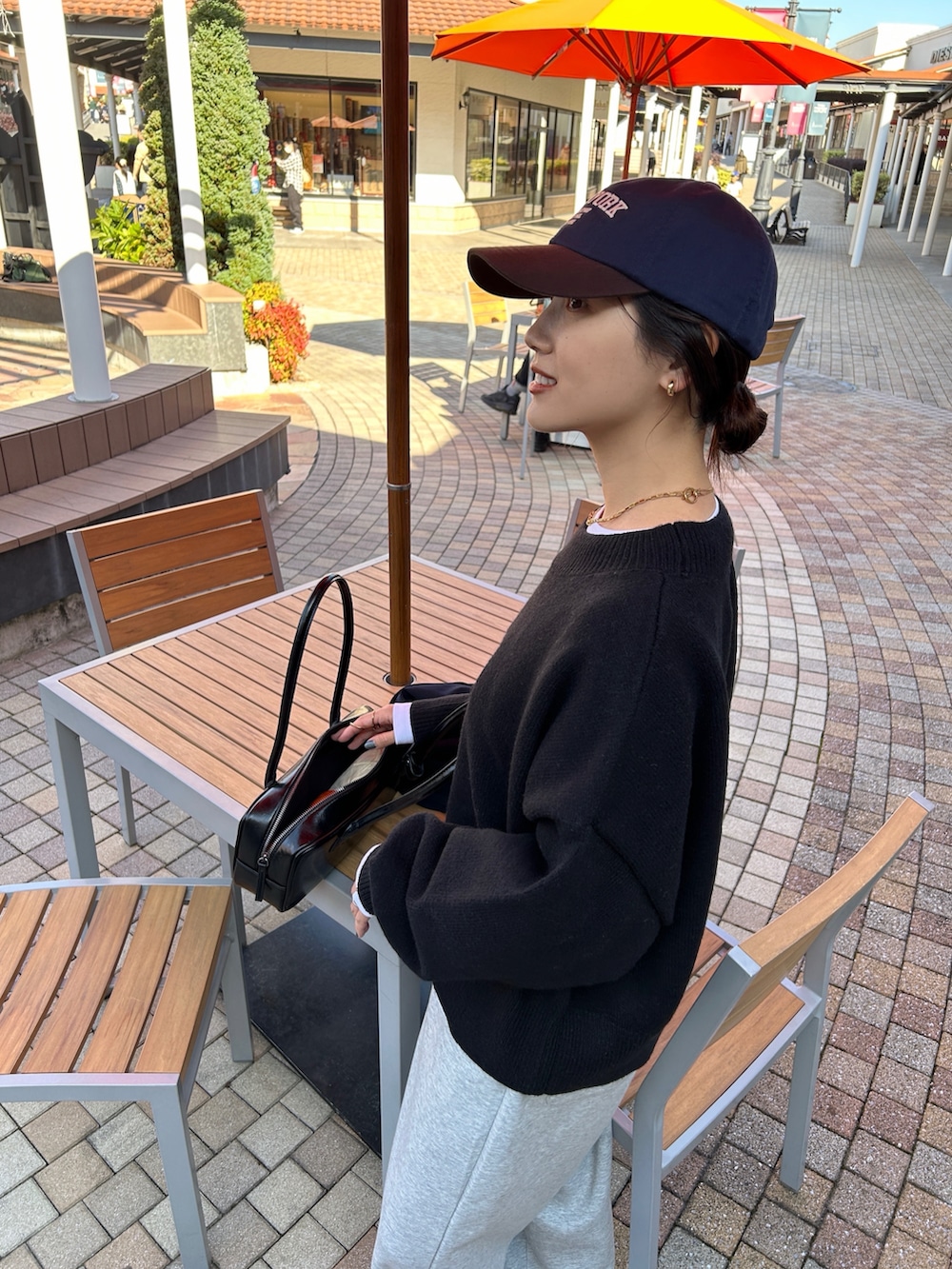 ブラック系のニット/セーター、ブルー系のテーラードジャケット、ブラック系のパンプスを着用したレディースの冬コーディネートの2枚目の写真