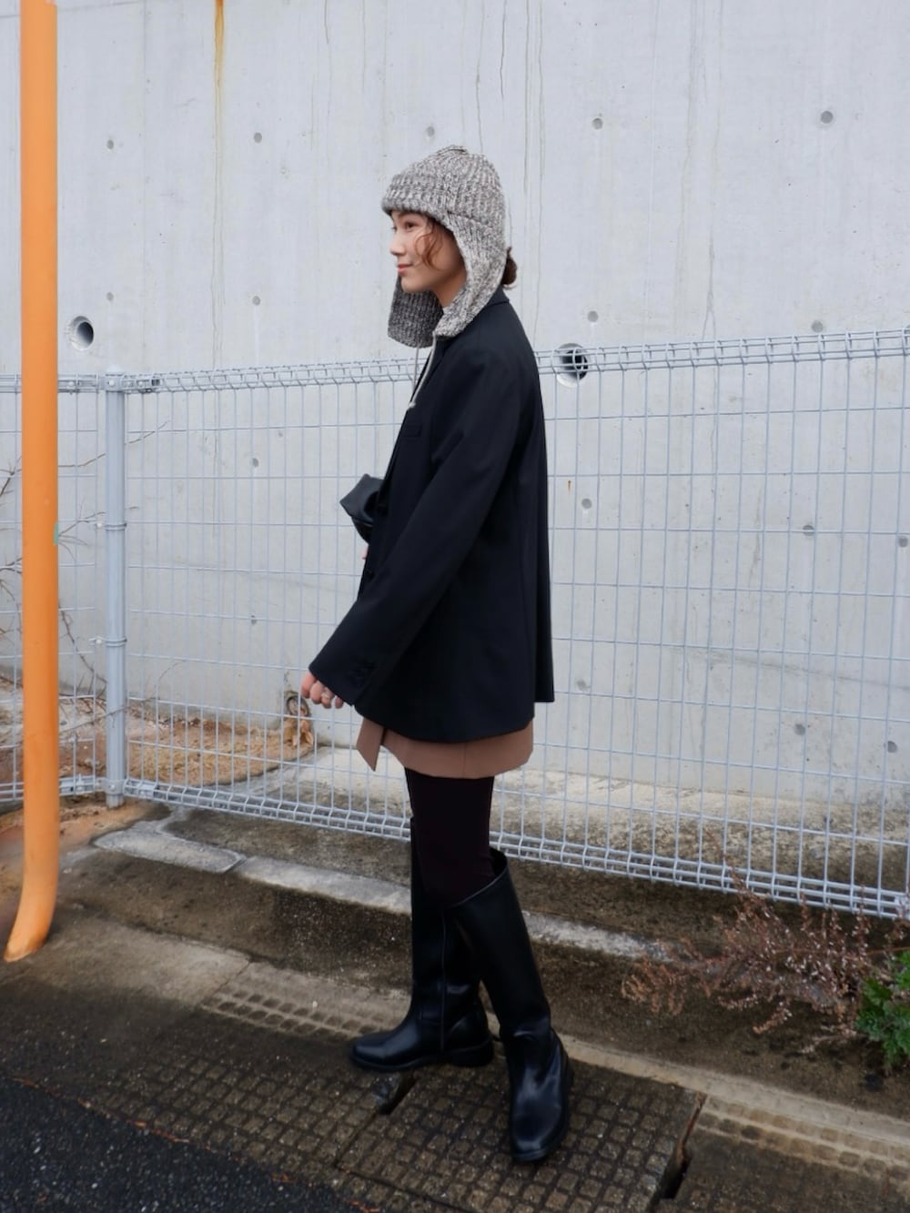 ホワイト系のニット/セーター、ブラウン系のスカート、ブラック系のブーツを着用したレディースの冬コーディネートの3枚目の写真