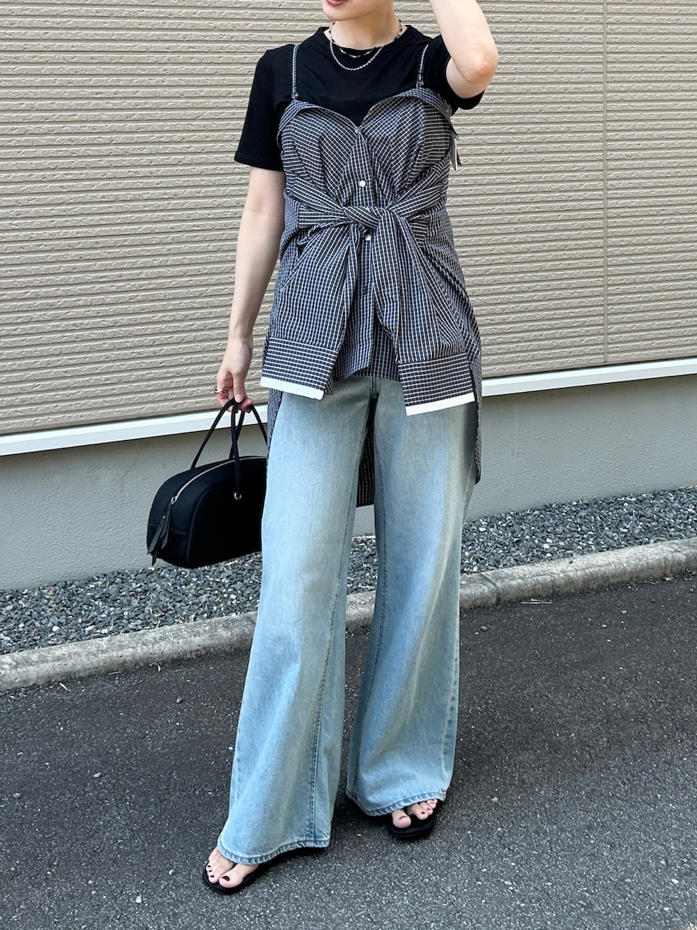 ブラック系のボストンバッグ、ホワイト系のシャツ/ブラウス、ブラック系のサンダルを着用したレディースの夏コーディネートの5枚目の写真
