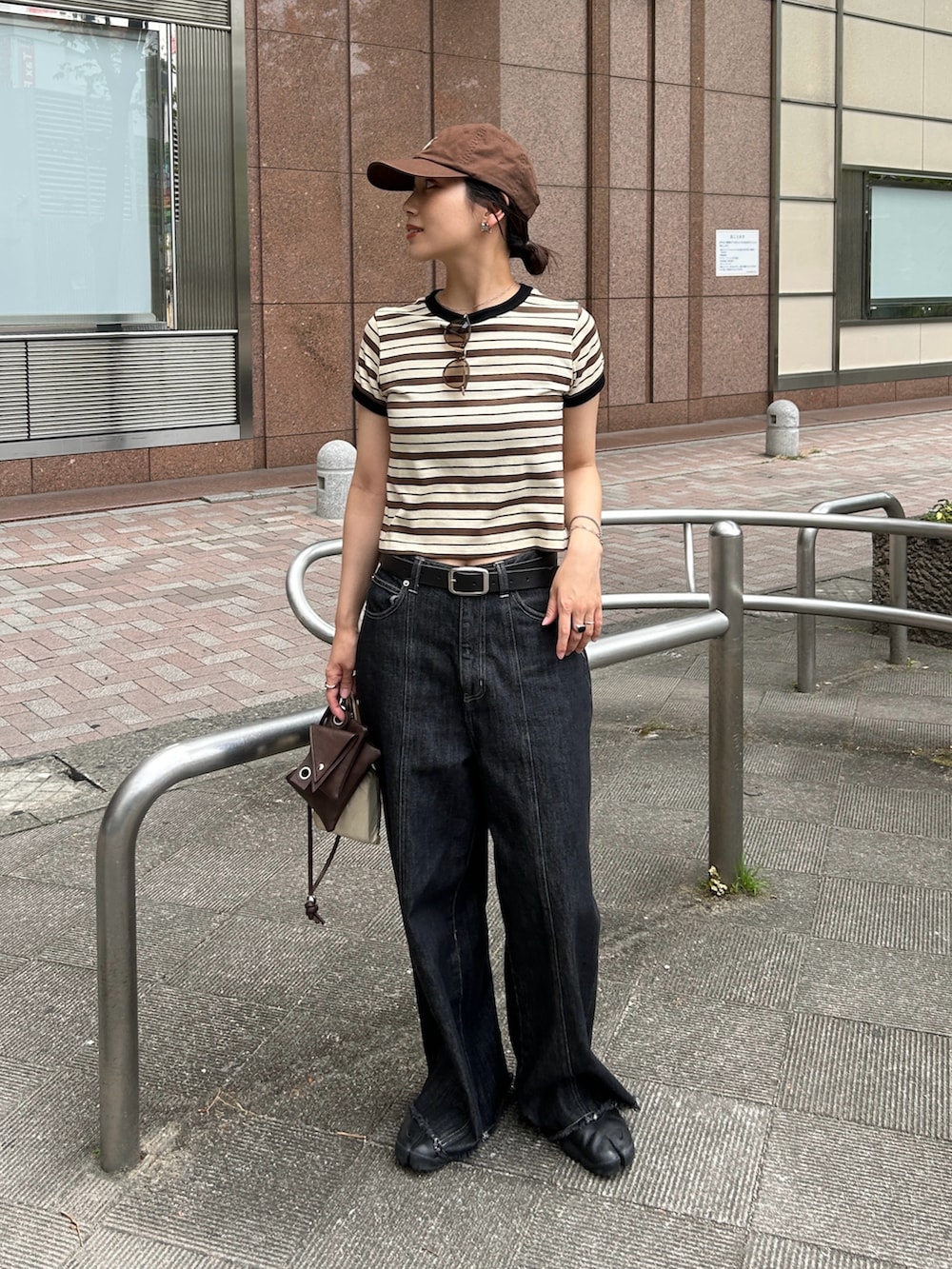 ブラック系のスニーカー、ホワイト系のTシャツ/カットソー、ブラウン系のショルダーバッグを着用したレディースの夏コーディネートの5枚目の写真