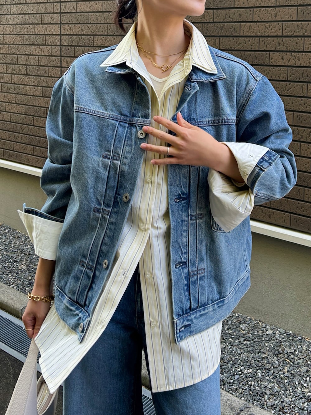 イエロー系のシャツ/ブラウス、ホワイト系のショルダーバッグ、ホワイト系のパンプスを着用したレディースの冬コーディネートの2枚目の写真