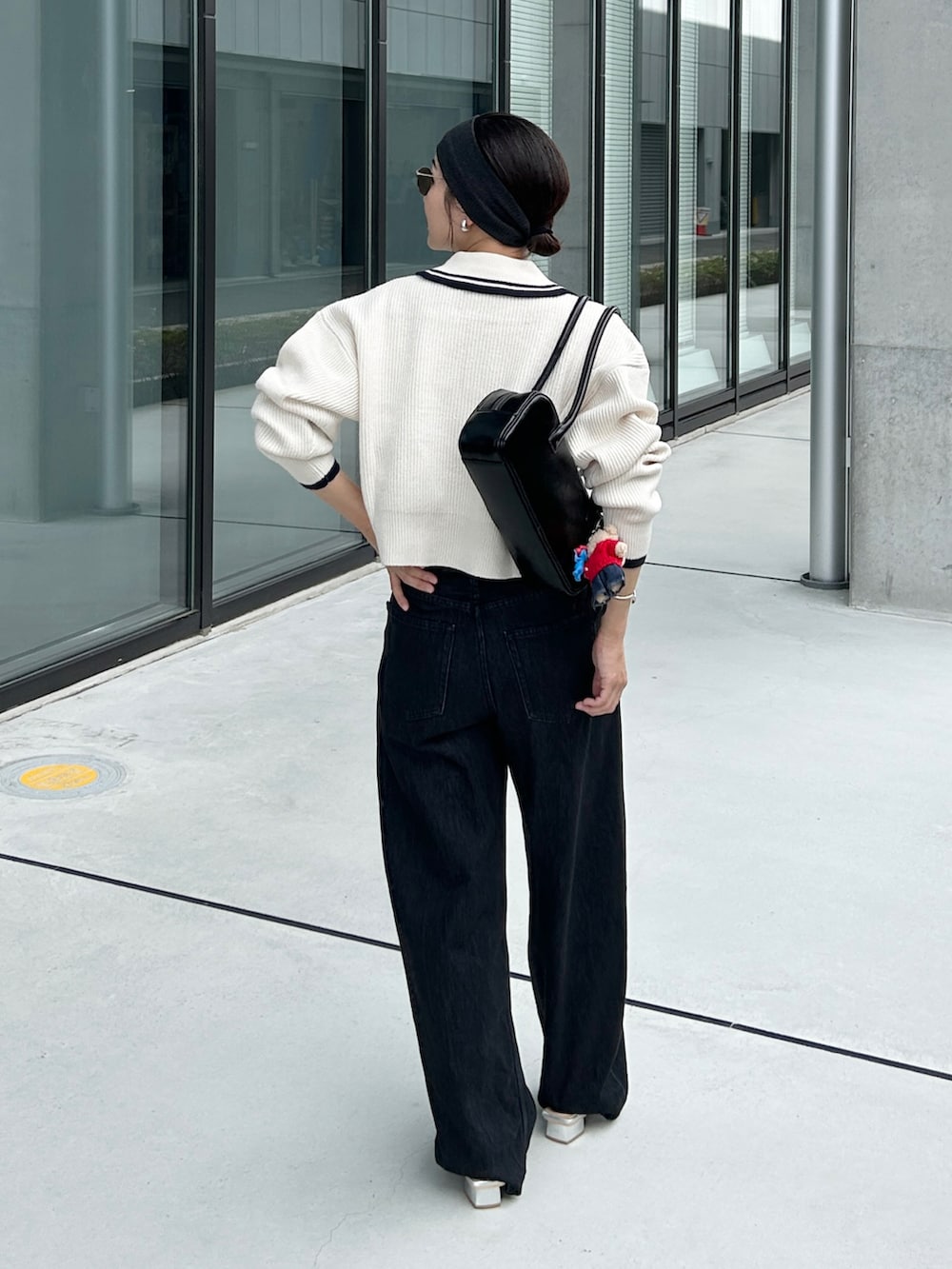 ホワイト系のニット/セーター、シルバー系のパンプス、ブラック系のデニムパンツを着用したレディースの秋コーディネートの4枚目の写真