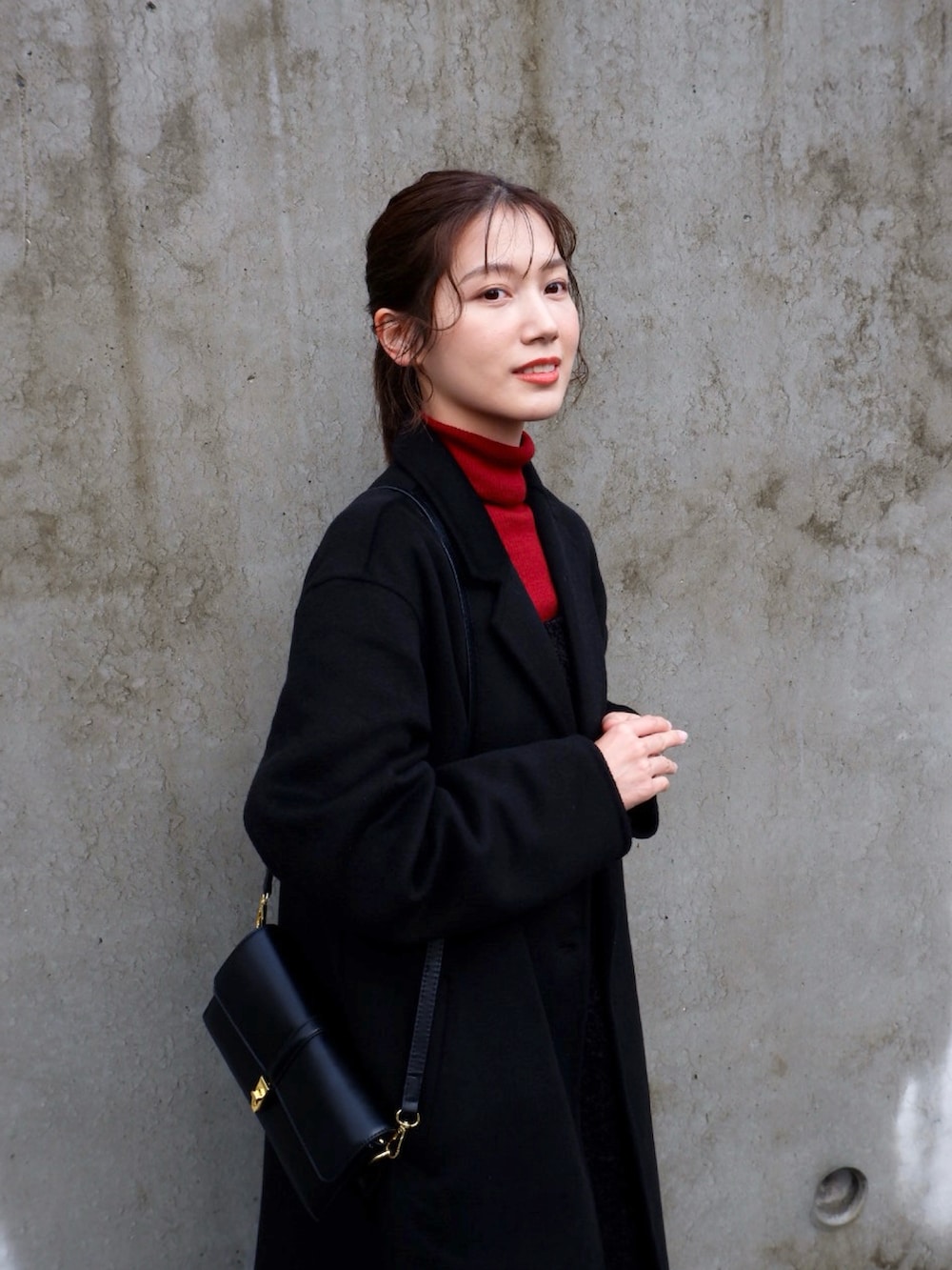 ブラック系のジャケット/アウター、ブラック系のワンピース、レッド系のニット/セーターを着用したレディースの冬コーディネートの2枚目の写真