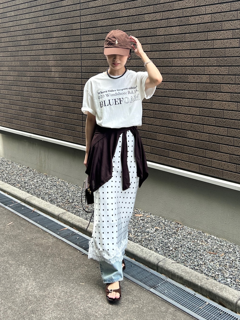 ホワイト系のスカート、ホワイト系のTシャツ/カットソー、ブルー系のデニムパンツを着用したレディースの春コーディネートの4枚目の写真