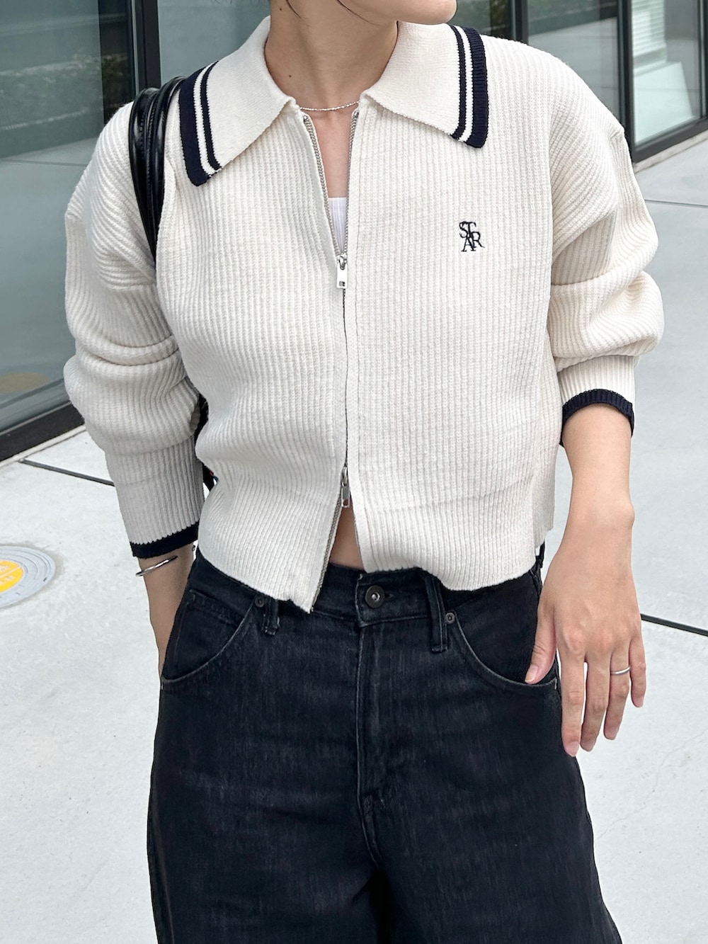 ホワイト系のニット/セーター、シルバー系のパンプス、ブラック系のデニムパンツを着用したレディースの秋コーディネートの3枚目の写真