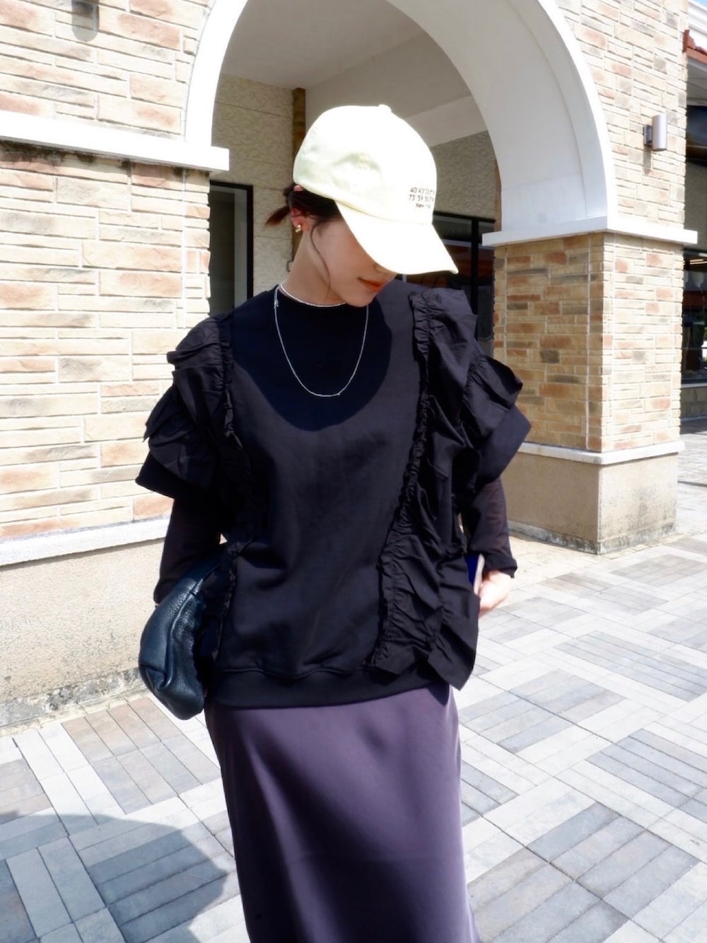 ブラック系のローファー、ブラック系のスウェット、ブラック系のハンドバッグを着用したレディースの春コーディネートの3枚目の写真