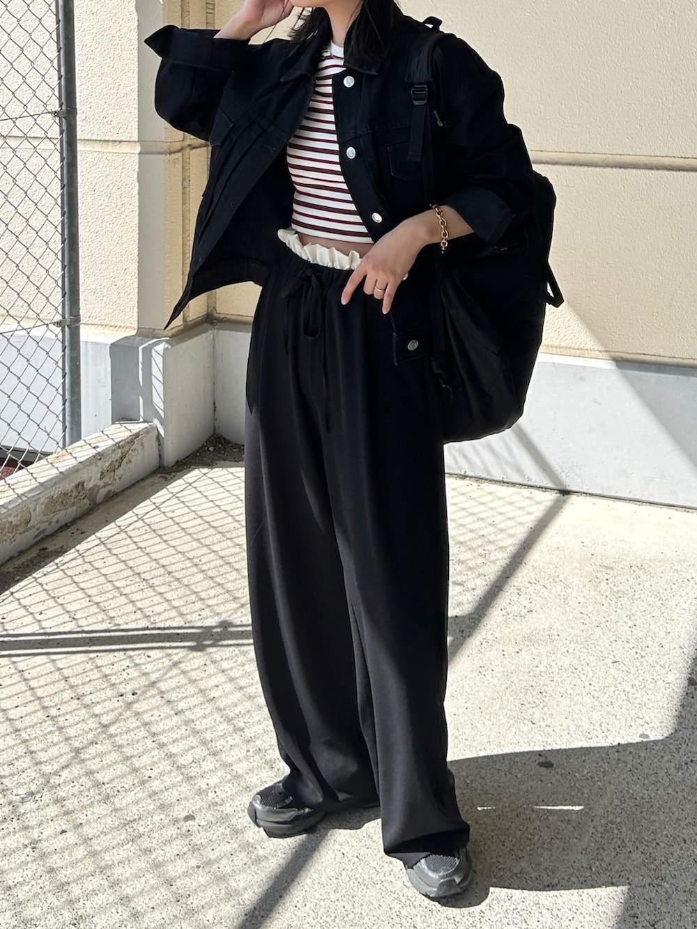 ブラック系のその他パンツ、ブラック系のスニーカー、ブラック系のデニムジャケットを着用したレディースの春コーディネートの2枚目の写真