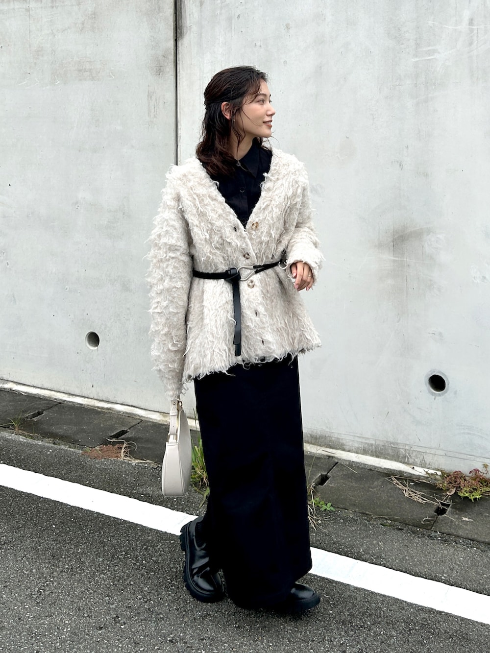 ホワイト系のハンドバッグ、ブラック系のシャツ/ブラウス、ブラック系のスカートを着用したレディースの秋コーディネートの3枚目の写真