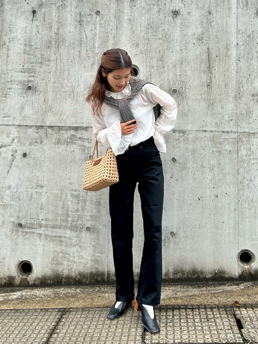 ブラック系のカーディガン/ボレロ、ホワイト系のシャツ/ブラウス、ブラック系のデニムパンツを着用したレディースの春コーディネートの2枚目の写真