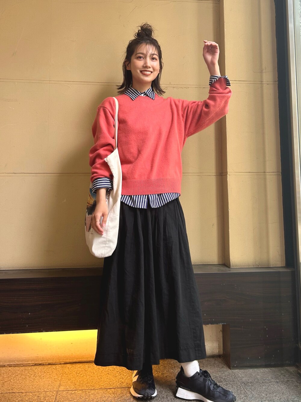 ピンク系のニット/セーター、ブルー系のシャツ/ブラウス、ホワイト系のトートバッグを着用したレディースの春コーディネートの2枚目の写真