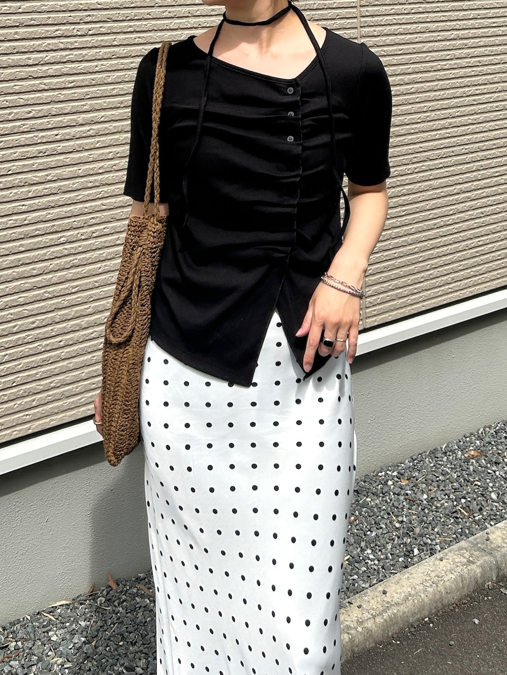 ブラック系のTシャツ/カットソー、ブラック系のスニーカー、ホワイト系のスカートを着用したレディースの春コーディネートの4枚目の写真