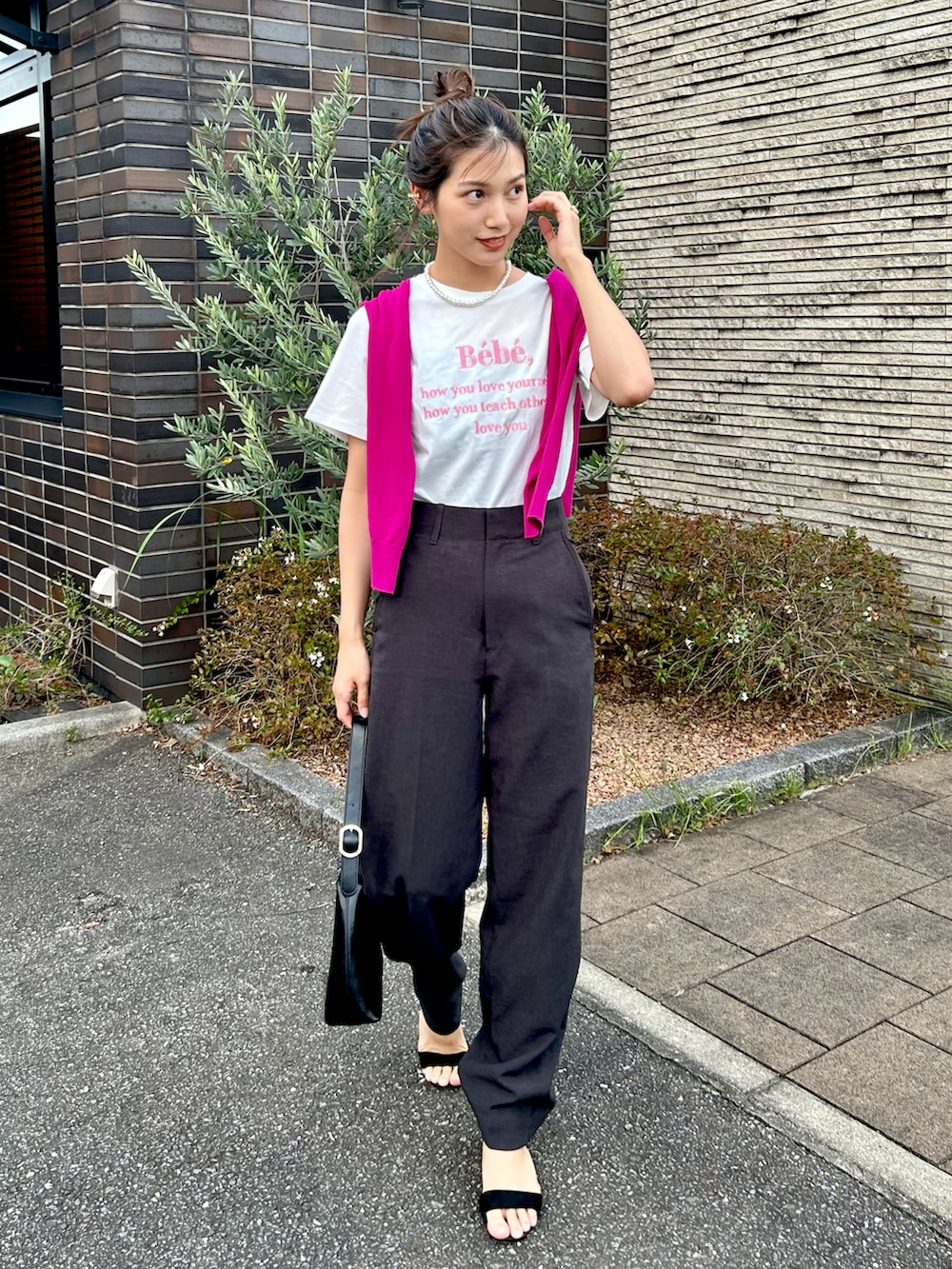 ホワイト系のTシャツ/カットソー、グレー系のパンツ、ブラック系のハンドバッグを着用したレディースの秋コーディネートの3枚目の写真