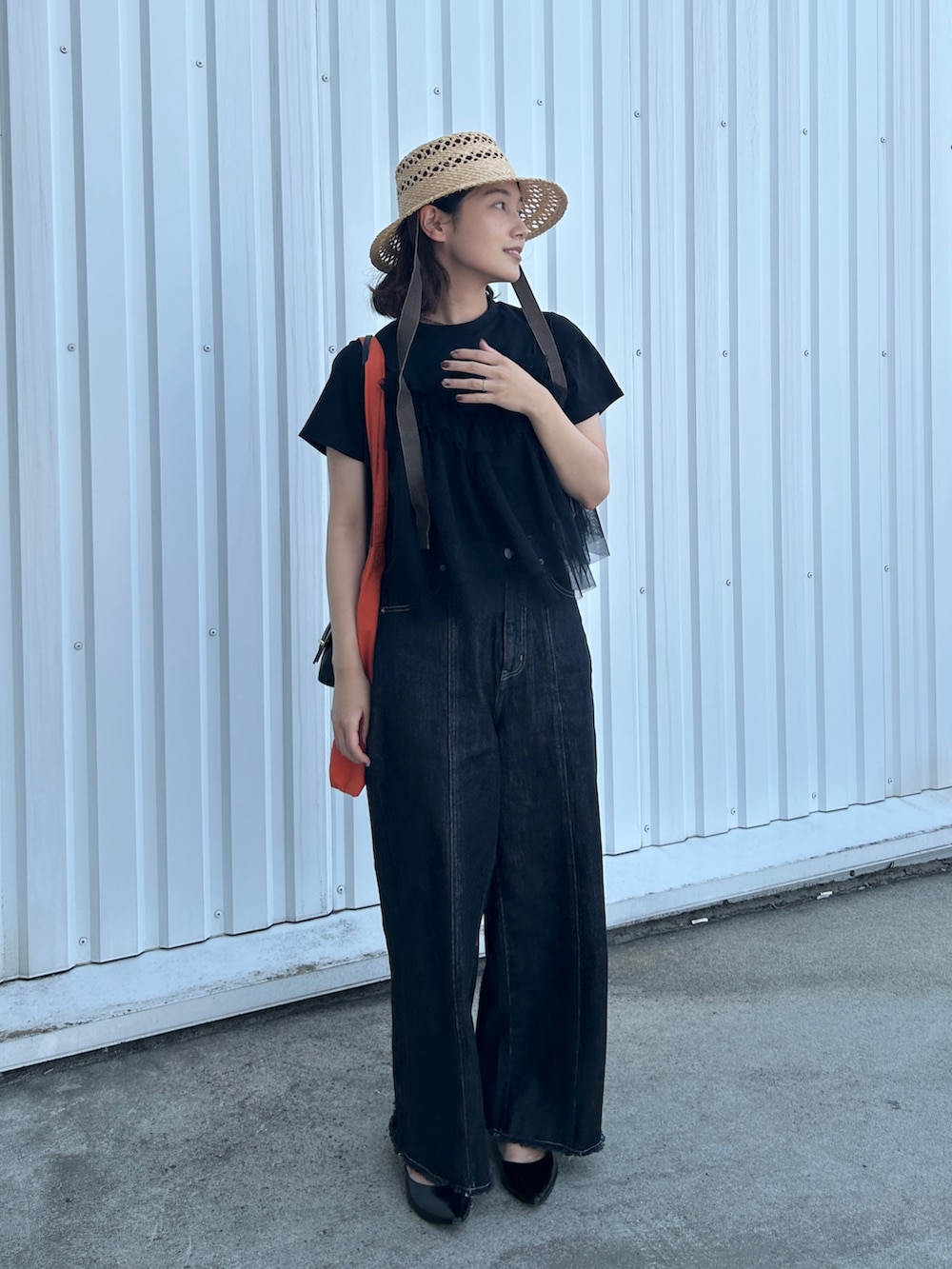 ブラック系のTシャツ/カットソー、オレンジ系のトートバッグ、ブラック系のショルダーバッグを着用したレディースの夏コーディネートの2枚目の写真