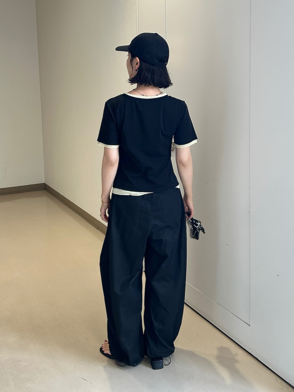 ブラック系のTシャツ/カットソー、ブラック系のその他パンツ、ブラック系のサンダルを着用したレディースの夏コーディネートの3枚目の写真