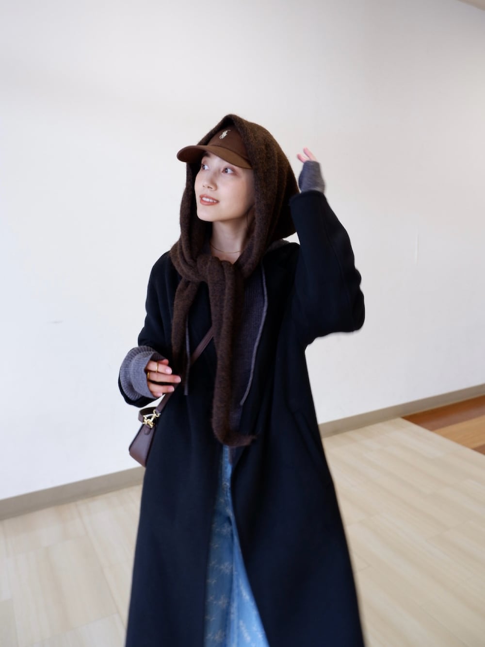 グレー系のパーカー、ブルー系のデニムパンツ、ブラック系のジャケット/アウターを着用したレディースの冬コーディネートの4枚目の写真