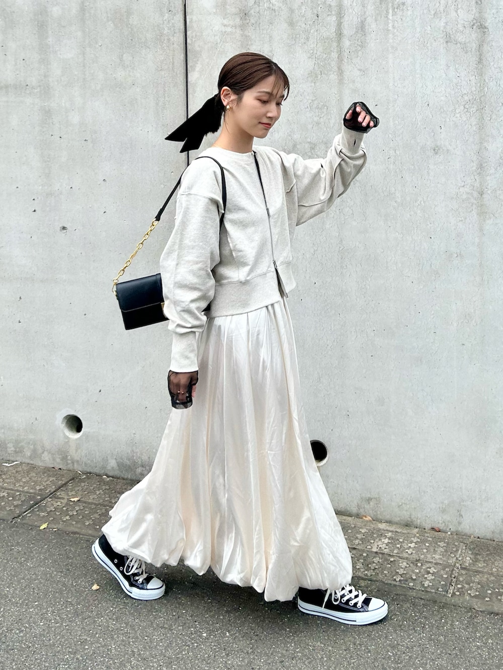 グレー系のスウェット、ブラック系のTシャツ/カットソー、ホワイト系のスカートを着用したレディースの春コーディネートの3枚目の写真