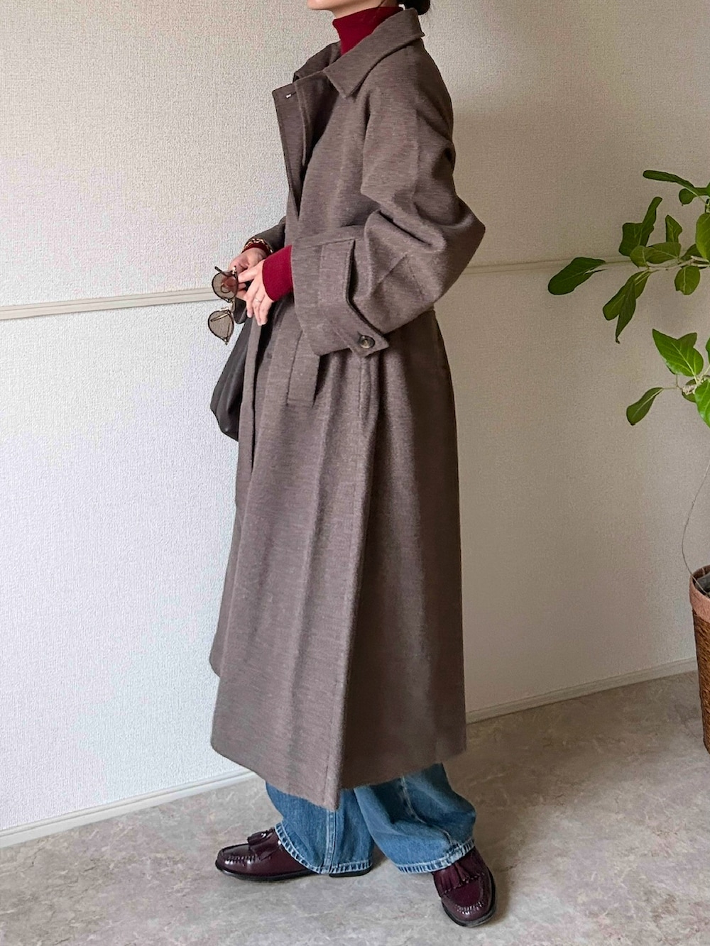 ブラウン系のステンカラーコート、レッド系のローファー、レッド系のニット/セーターを着用したレディースの冬コーディネートの4枚目の写真