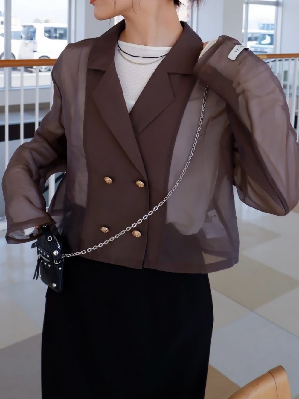 グリーン系のテーラードジャケット、ブラック系のローファー、ブラック系のスカートを着用したレディースの春コーディネートの2枚目の写真