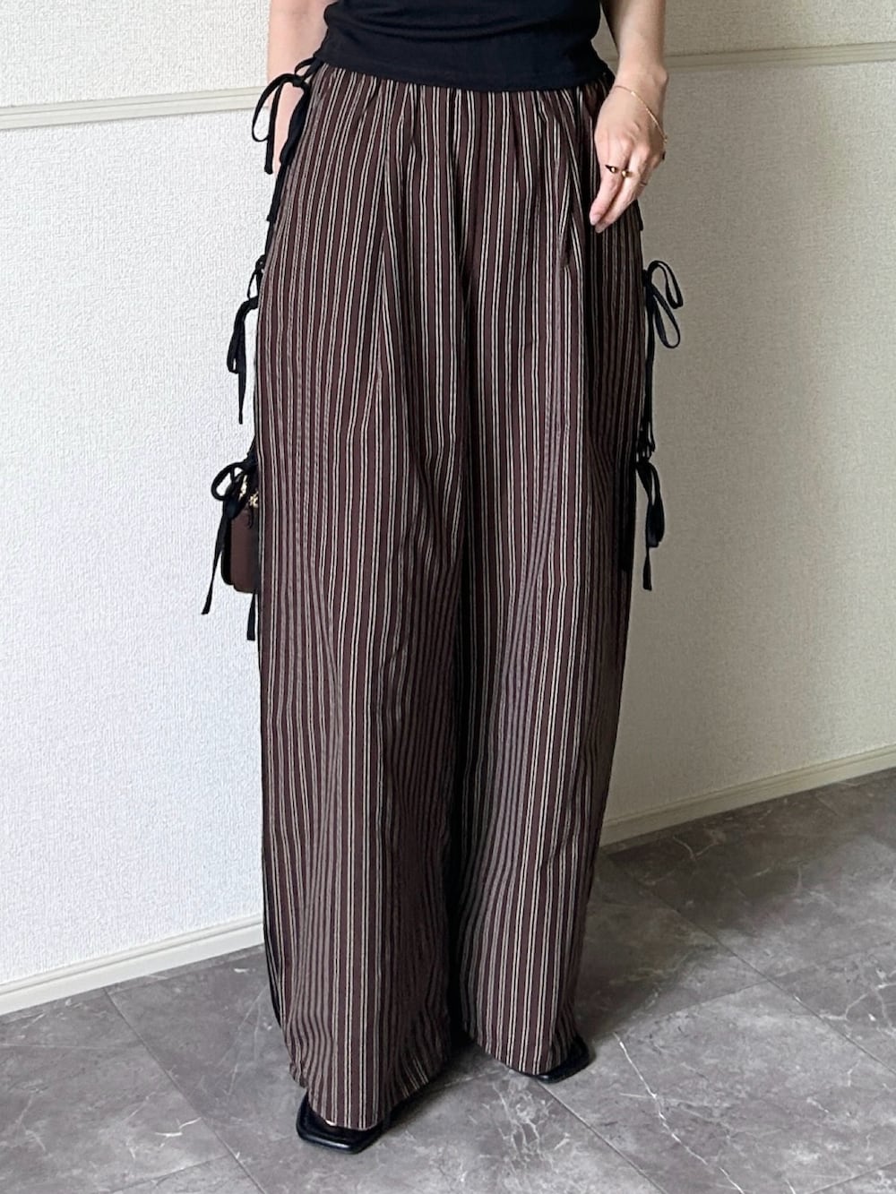 ブラック系のサンダル、ブラウン系のその他パンツ、ブラック系のTシャツ/カットソーを着用したレディースの夏コーディネートの3枚目の写真