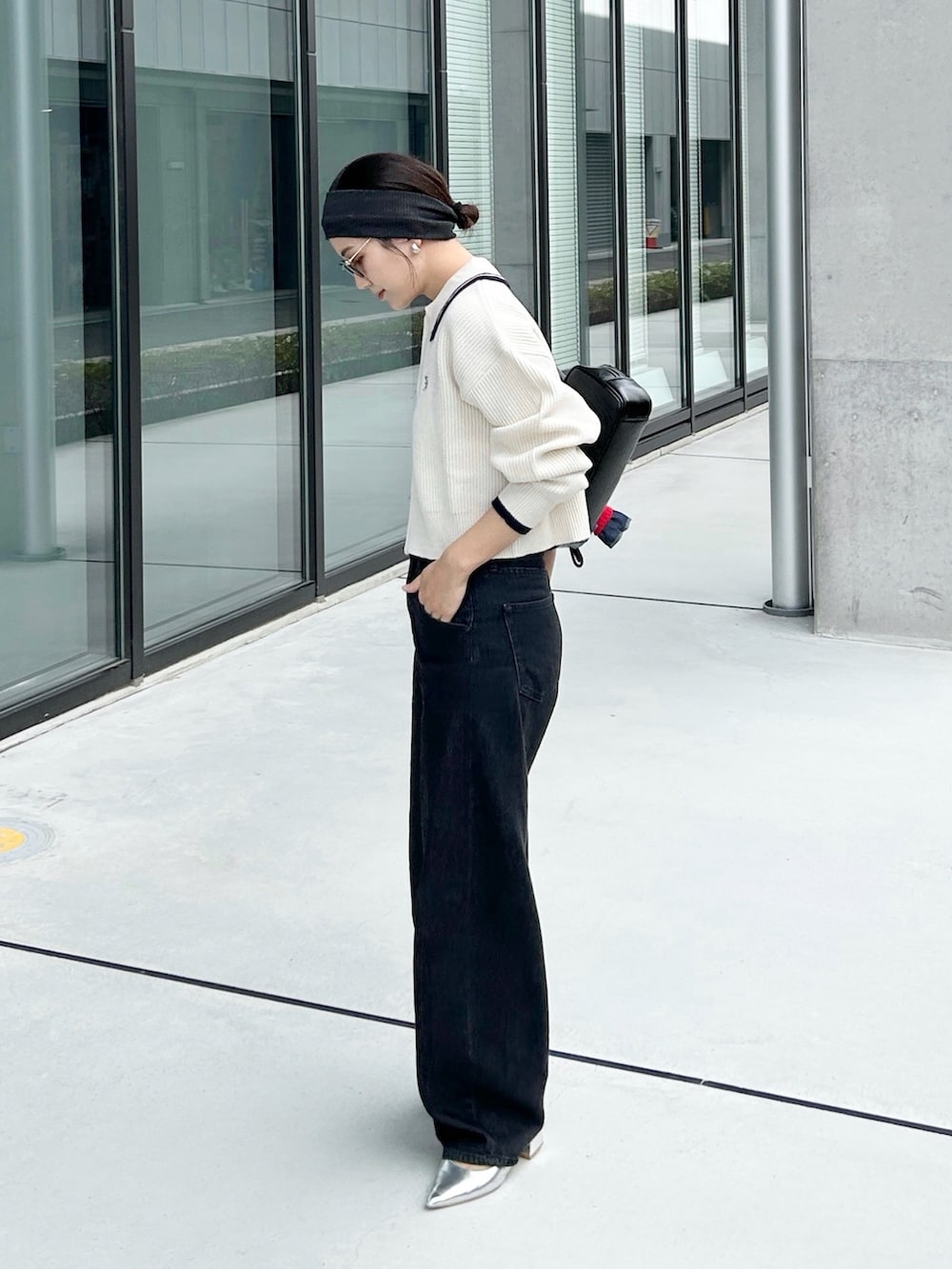 ホワイト系のニット/セーター、シルバー系のパンプス、ブラック系のデニムパンツを着用したレディースの秋コーディネートの2枚目の写真