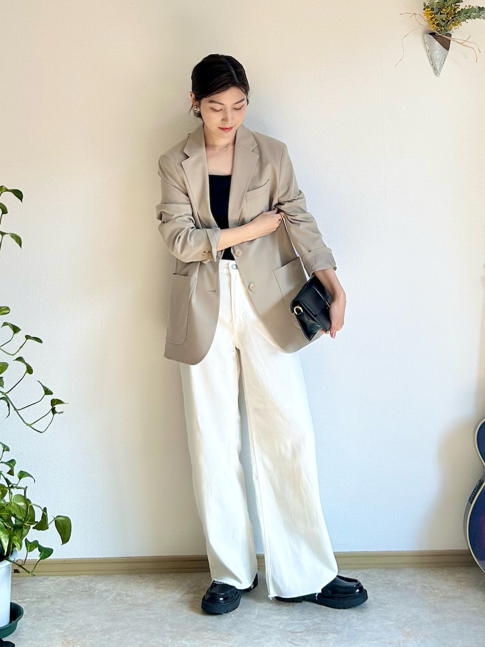 ブラック系のショルダーバッグ、ブラック系のローファー、ゴールド系のリングを着用したレディースの春コーディネートの2枚目の写真