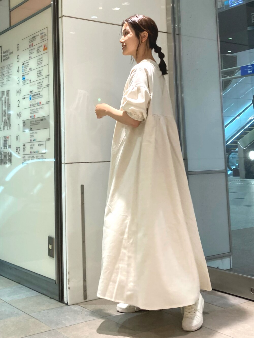 ブラック系のバッグ、ホワイト系のワンピース、ホワイト系のスニーカーを着用したレディースの春コーディネートの3枚目の写真