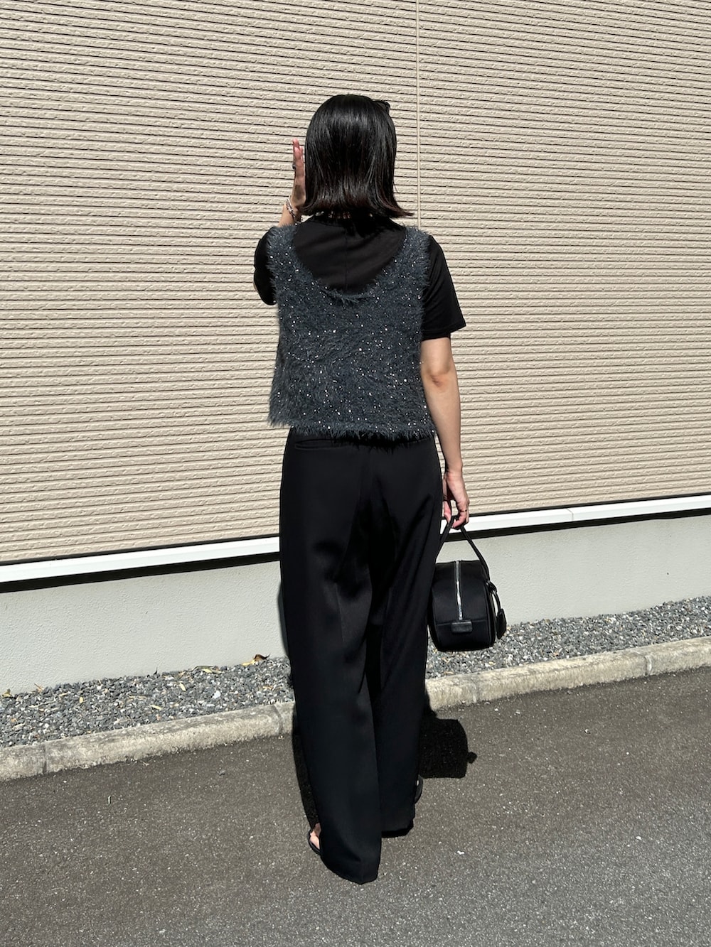 グレー系のベスト、ブラック系のボストンバッグ、ブラック系のサンダルを着用したレディースの夏コーディネートの5枚目の写真