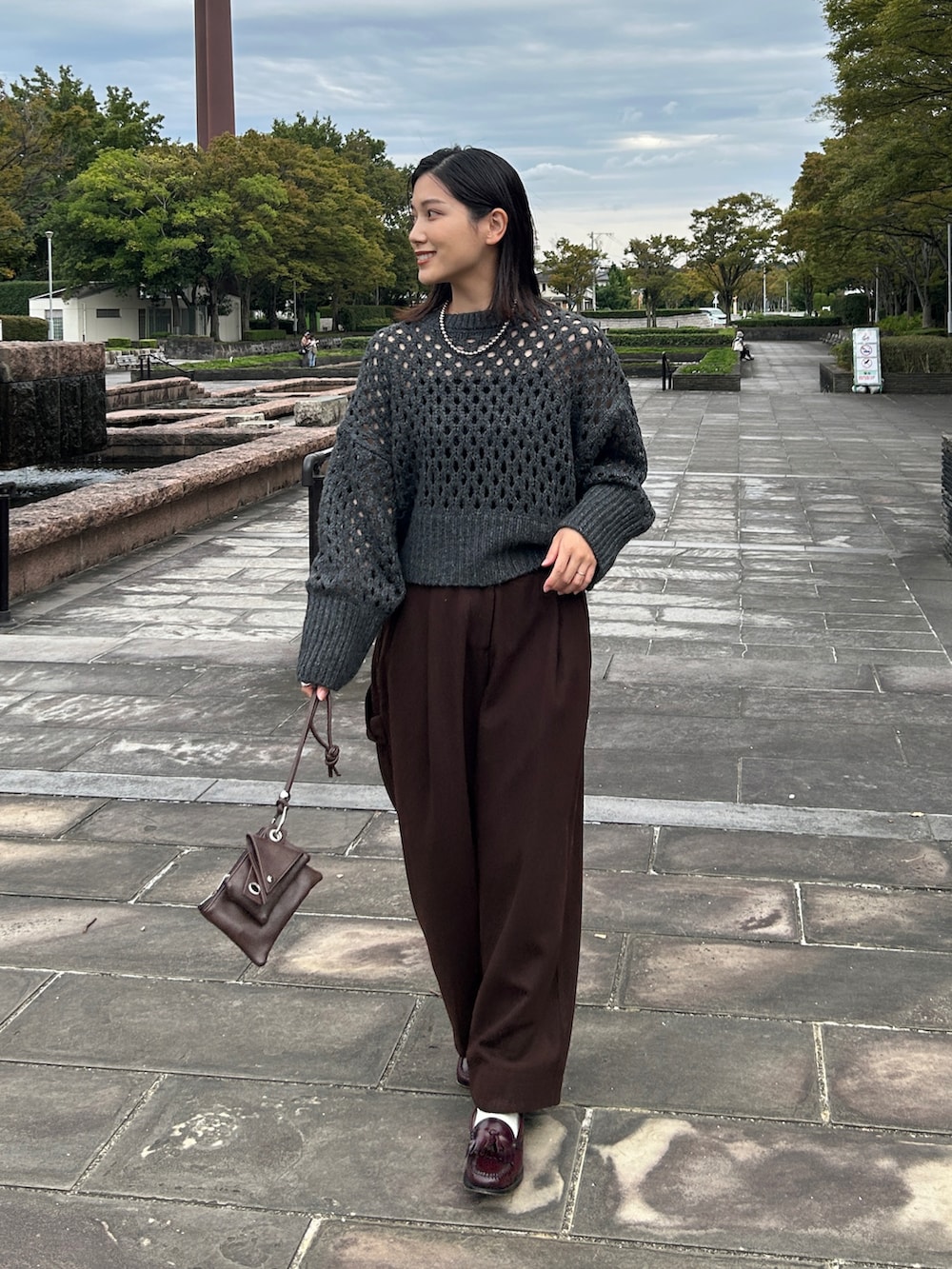 グレー系のニット/セーター、ブラウン系のショルダーバッグ、レッド系のローファーを着用したレディースの秋コーディネートの5枚目の写真