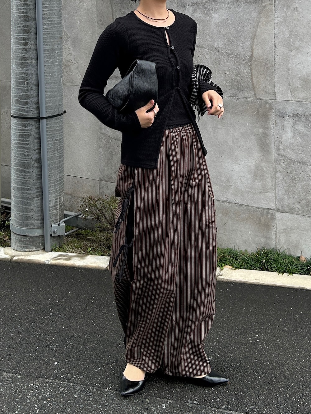 ブラウン系のその他パンツ、ブラック系のTシャツ/カットソー、ブラック系のハンドバッグを着用したレディースの春コーディネートの2枚目の写真