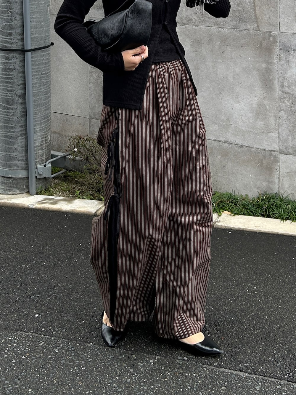 ブラウン系のその他パンツ、ブラック系のTシャツ/カットソー、ブラック系のハンドバッグを着用したレディースの春コーディネートの4枚目の写真