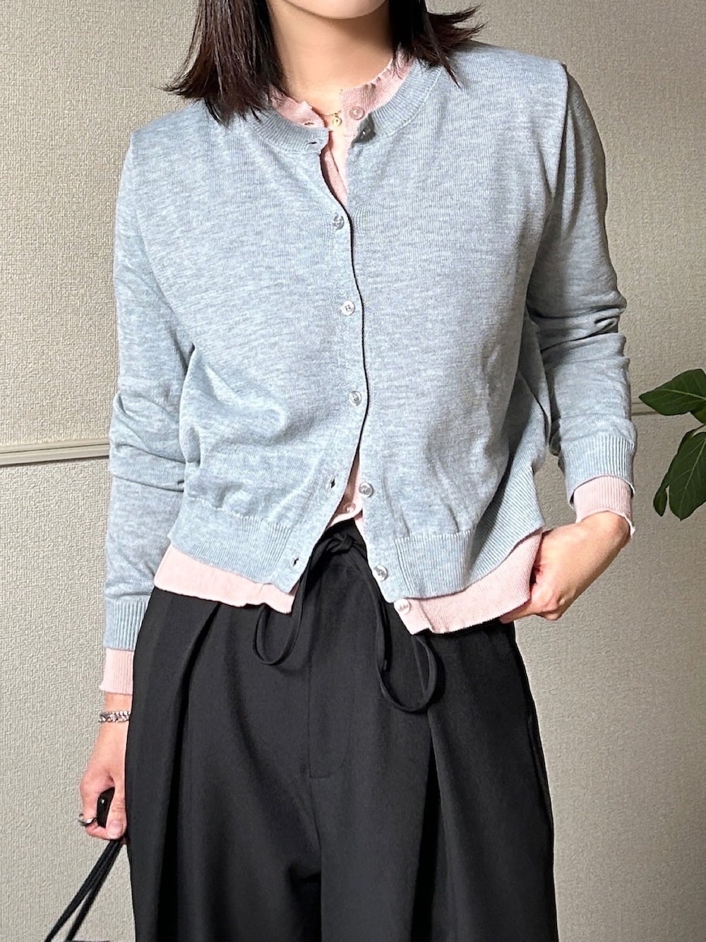 グレー系のカーディガン/ボレロ、ブラック系のボストンバッグ、ブラック系のスラックスを着用したレディースの春コーディネートの2枚目の写真