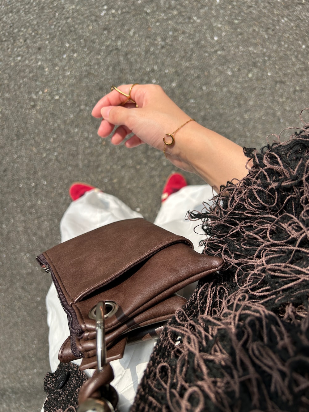 ブラック系のカーディガン/ボレロ、ブラウン系のショルダーバッグ、レッド系のスニーカーを着用したレディースの秋コーディネートの3枚目の写真