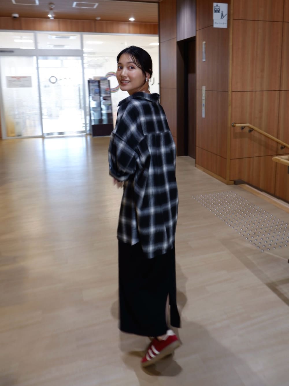 ブラック系のシャツ/ブラウス、ブラック系のワンピース、レッド系のスニーカーを着用したレディースの秋コーディネートの4枚目の写真