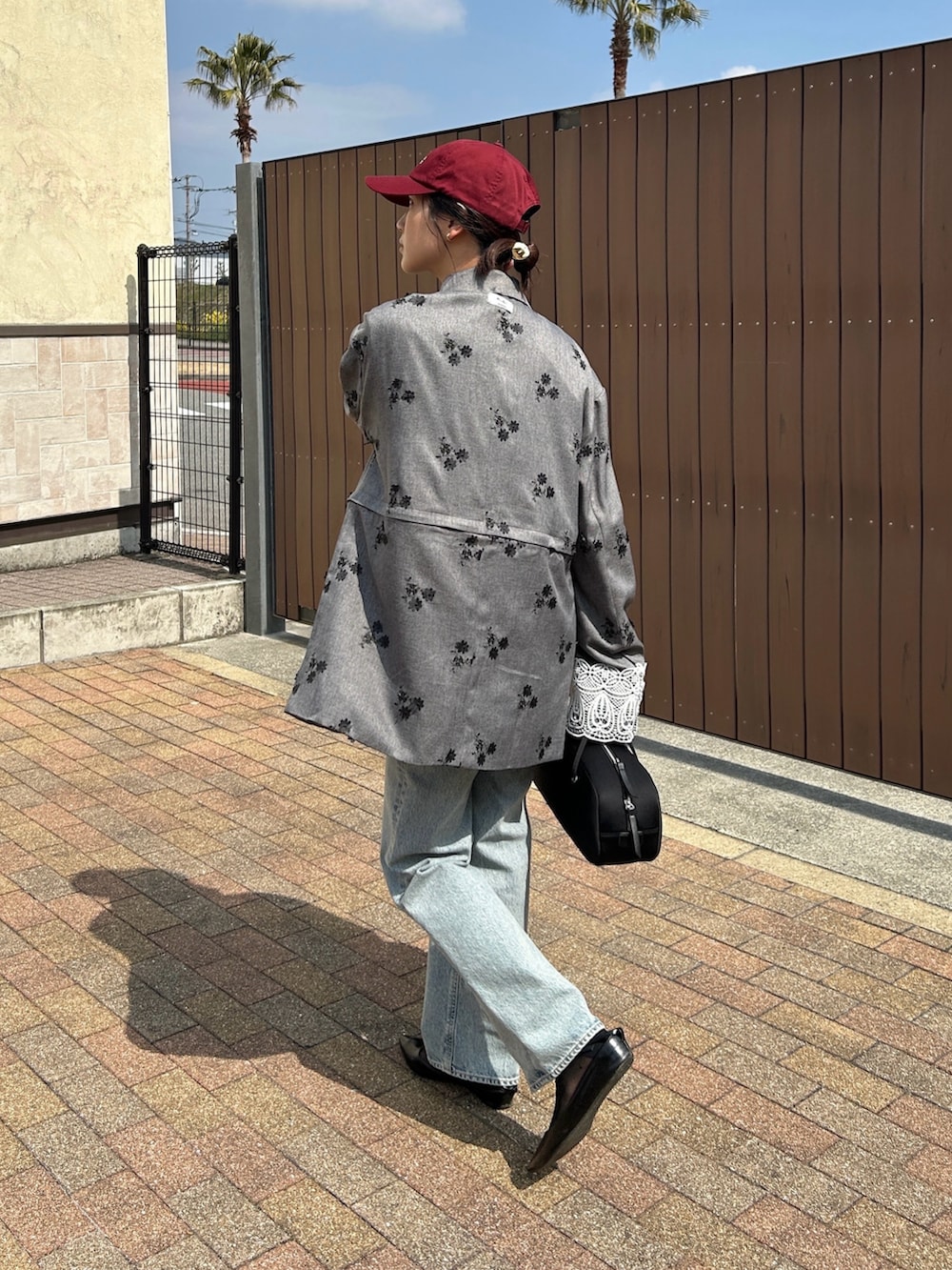 ブラック系のテーラードジャケット、ブラック系のボストンバッグ、ブラック系のパンプスを着用したレディースの春コーディネートの3枚目の写真