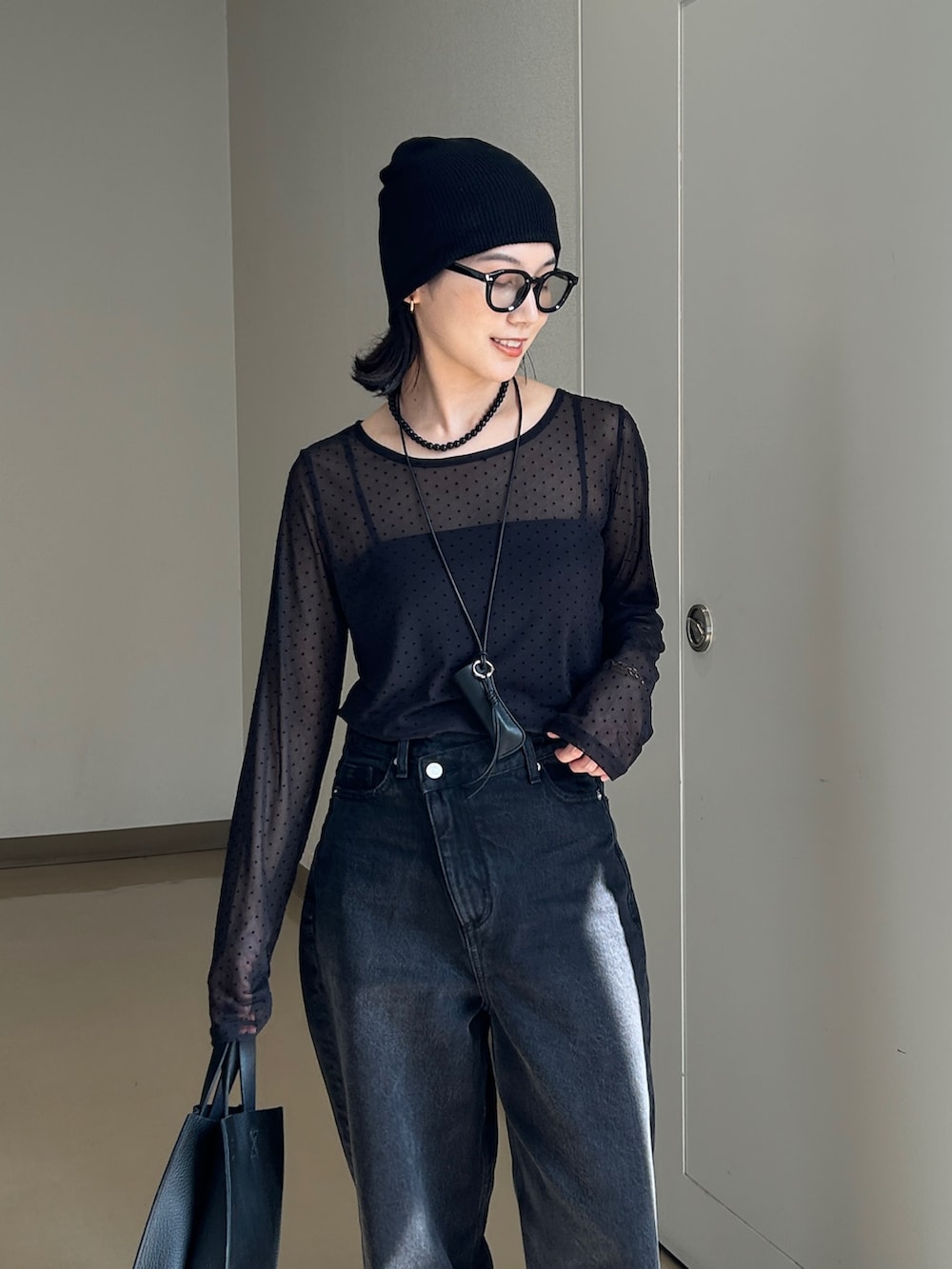 ブラック系のTシャツ/カットソー、ブラック系のデニムパンツ、ブラック系のハンドバッグを着用したレディースの秋コーディネートの3枚目の写真