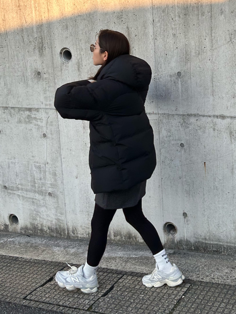 グレー系のスウェット、ホワイト系のTシャツ/カットソー、ブラック系のスカートを着用したレディースの冬コーディネートの3枚目の写真