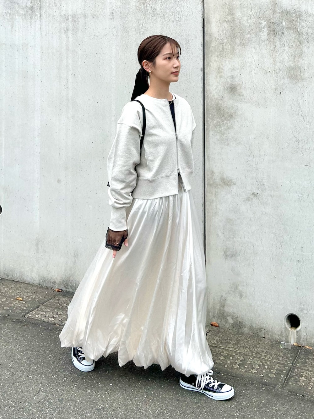 グレー系のスウェット、ブラック系のTシャツ/カットソー、ホワイト系のスカートを着用したレディースの春コーディネートの2枚目の写真