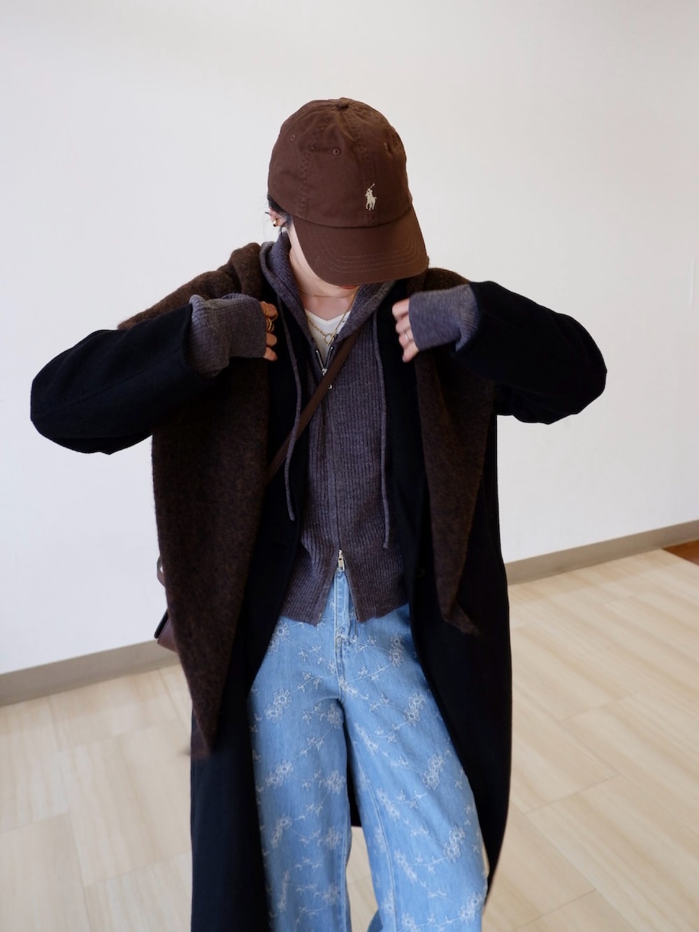 グレー系のパーカー、ブルー系のデニムパンツ、ブラック系のジャケット/アウターを着用したレディースの冬コーディネートの2枚目の写真