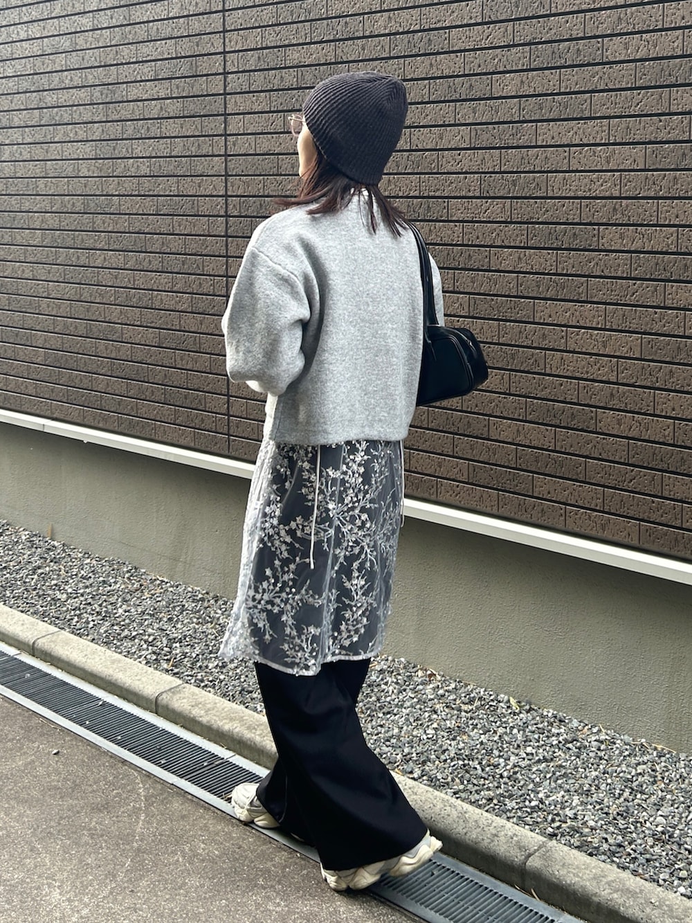 グレー系のカーディガン/ボレロ、シルバー系のワンピース、ブラック系のスラックスを着用したレディースの冬コーディネートの5枚目の写真