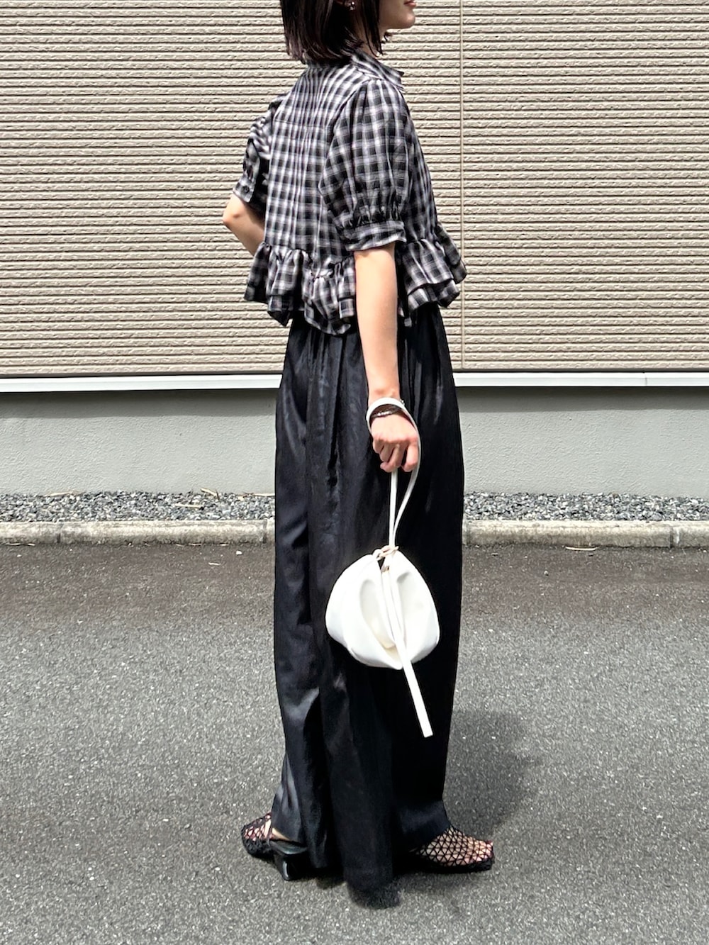 ブラック系のサンダル、ブラック系のシャツ/ブラウス、ブラック系のパンツを着用したレディースの夏コーディネートの2枚目の写真