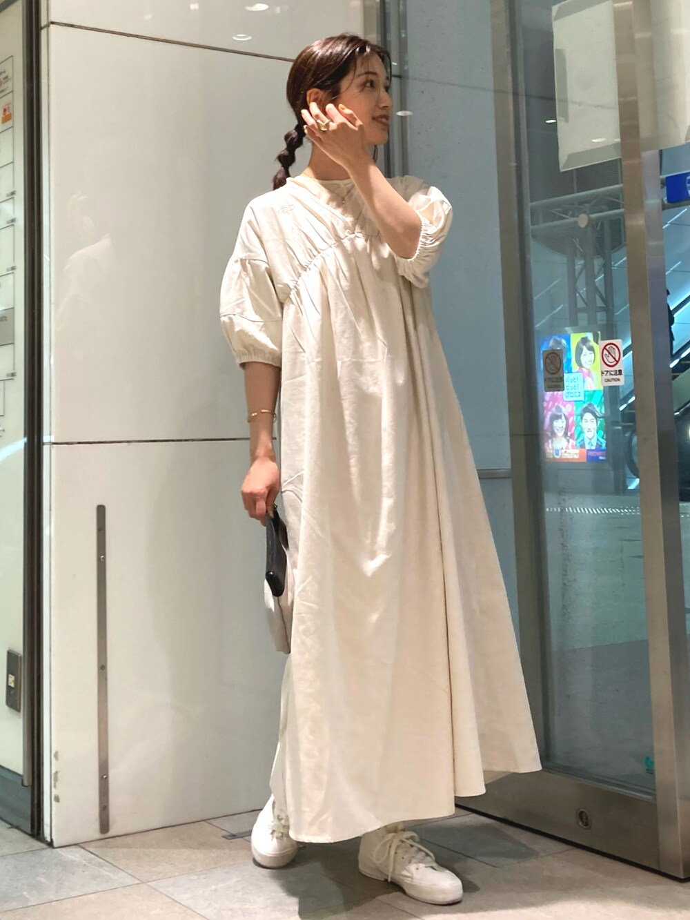 ブラック系のバッグ、ホワイト系のワンピース、ホワイト系のスニーカーを着用したレディースの春コーディネートの4枚目の写真