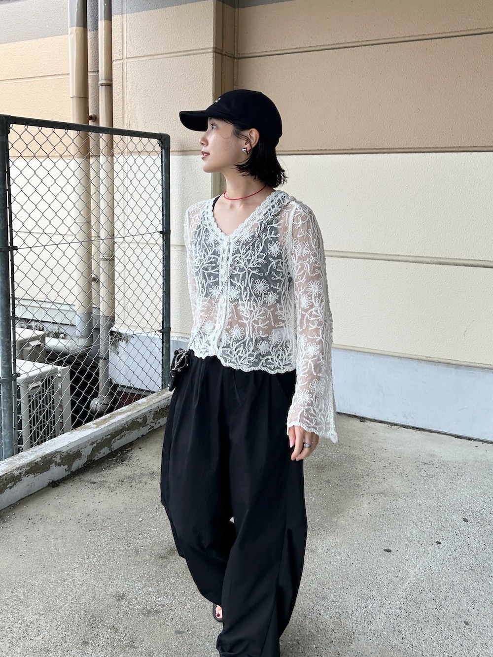 ブラック系のその他パンツ、ホワイト系のカーディガン/ボレロ、ブラック系のサンダルを着用したレディースの夏コーディネートの2枚目の写真