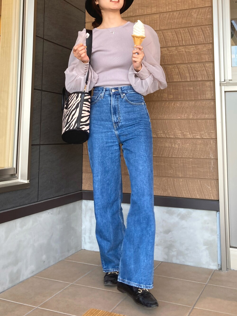 パープル系のニット/セーター、その他のバッグ、ブルー系のデニムパンツを着用したレディースの春コーディネートの2枚目の写真