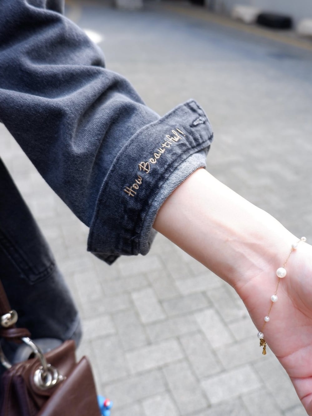 ブラック系のパンプス、ブラック系のデニムジャケット、ブラック系のデニムパンツを着用したレディースの秋コーディネートの2枚目の写真