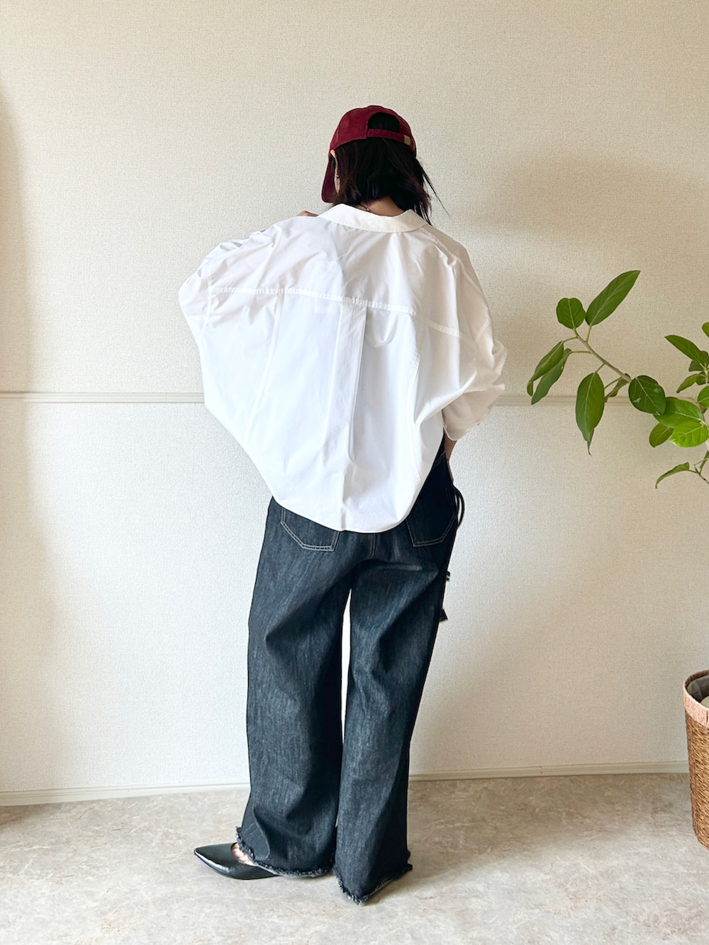 ブラック系のデニムパンツ、ブラック系のパンプス、ブラウン系のショルダーバッグを着用したレディースの秋コーディネートの2枚目の写真