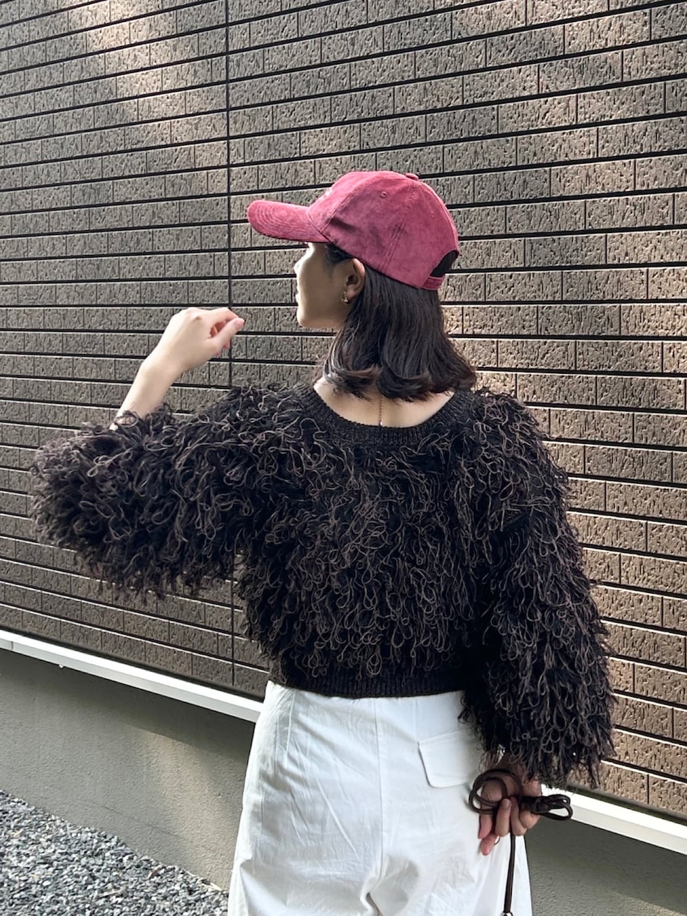 ブラック系のカーディガン/ボレロ、ブラウン系のショルダーバッグ、レッド系のスニーカーを着用したレディースの秋コーディネートの5枚目の写真