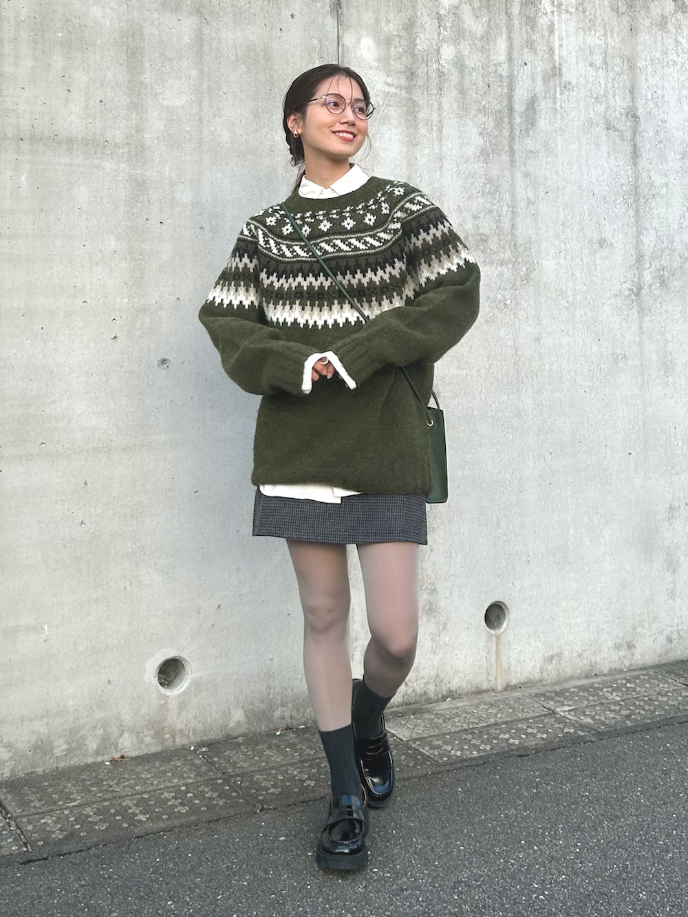 ホワイト系のシャツ/ブラウス、グリーン系のニット/セーター、ブラック系のスカートを着用したレディースの秋コーディネートの3枚目の写真